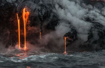 Parallel thin streams of lava pouring into the sea. (Photo: Tom Pfeiffer)
