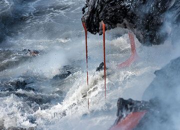 La lave s'égoutte dans l'eau agitée de l'océan. (Photo: Tom Pfeiffer)