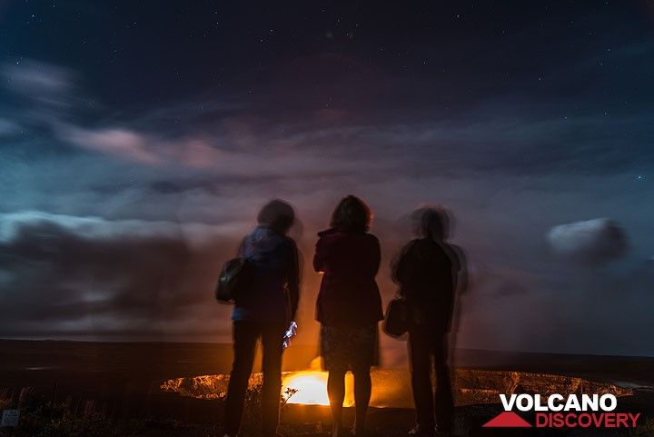A group of friends stand on the terrace watching the lava lake in front of them. (Photo: Tom Pfeiffer)