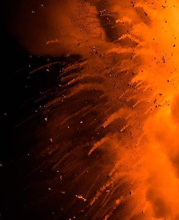 View of the trailing lava bombs falling back into the sea at night. (Photo: Tom Pfeiffer)