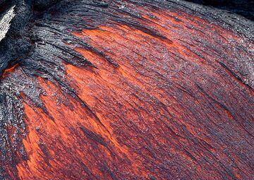 Relatively fast-flowing lava oozing out from a larger breakout point. The heat radiation is so strong that it is only possible to have the camera near it wearing gloves and long-sleeved clothes, and even so, the lens can only stand it for a fraction of a second without being burned. (Photo: Tom Pfeiffer)