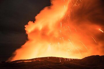 A stronger littoral explosion sends bright lava bombs to tens of meters above the cliff. In the moonless night, the glow appears yellow. (Photo: Tom Pfeiffer)