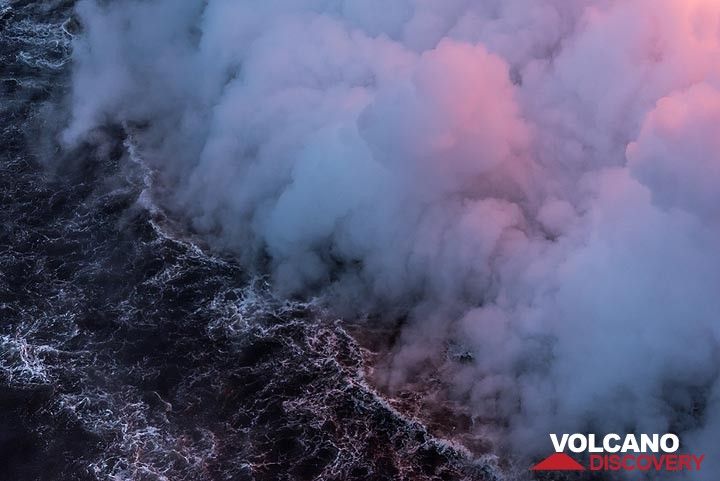 Bluish and pink steam from the lava entry hovering above the ocean surface. (Photo: Tom Pfeiffer)
