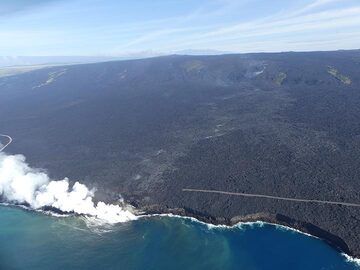 Jour d'extension 3 : Vue aérienne de l'entrée de l'océan de lave de Kamukona, avec la route asphaltée détruite par les coulées de lave précédentes, la traînée de vapeur marquant le chemin souterrain de la lave et le nuage de vapeur marquant le bouclier de lave Pu'u O'o et le cratère actif. au fond central (Photo: Ingrid Smet)