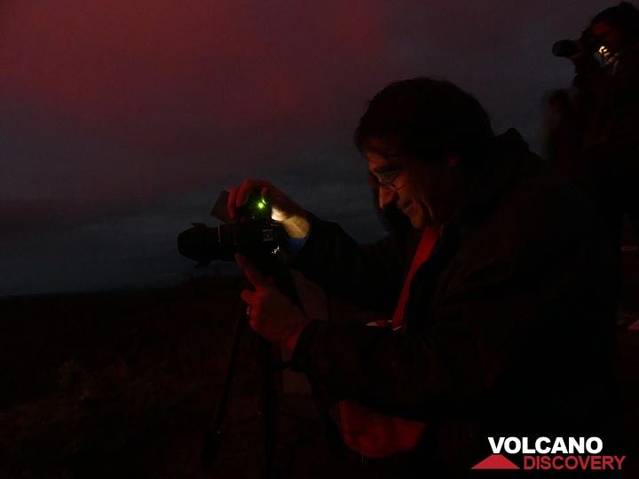 The red glow of the lava lake, 1 km away, reflects on the faces on early rise observers and photographers (Photo: Ingrid Smet)