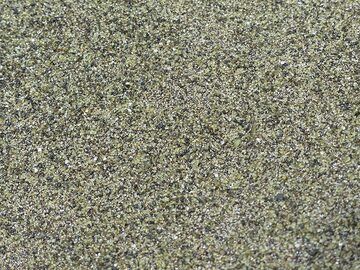 Close-up of the green sand at Green Sand Beach, made up mostly of green olivine crystals besides some black lava grains and white shell pieces (Photo: Ingrid Smet)