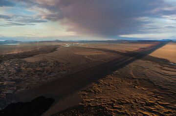 The eruption plume and the shadow of the steam column stretch over the vast plain. (Photo: Tom Pfeiffer)