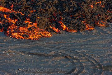 The lava spreads over the sandy surface, wiping out traces of jeeps. (Photo: Tom Pfeiffer)