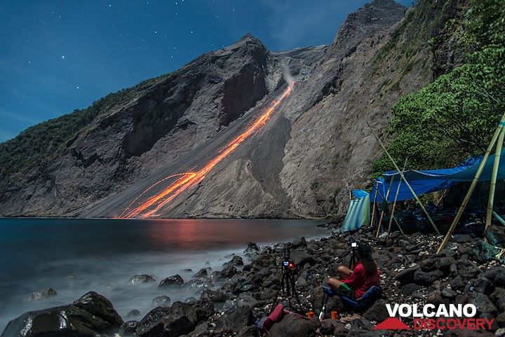 Glowing rockfalls after a nice night-time eruption; our camp to the right. (Photo: Tom Pfeiffer)