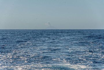 Am fernen Horizont ist der Vulkan Batu Tara mit einer Eruptionswolke zu sehen. (Photo: Tom Pfeiffer)