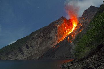 A strong strombolian explosion on 25 Nov evening throws glowing bombs over much of the upper eastern flanks of the volcano, and lava blocks start to roll down on the slope. (Photo: Tom Pfeiffer)