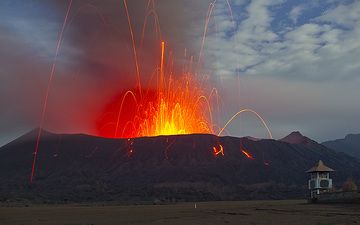 Una poderosa explosión de tipo vulcaniano sacude el suelo. Muchas bombas incandescentes se lanzan a cientos de metros hacia el cielo nocturno y muchas de ellas caen fuera del cráter. Tenga en cuenta que la mayoría de los bloques en realidad NO brillan, (Photo: Tom Pfeiffer)