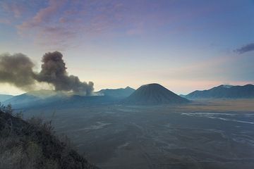 Bromo emitting dense ash clouds seen at dawn from the caldera rim (Photo: Tom Pfeiffer)