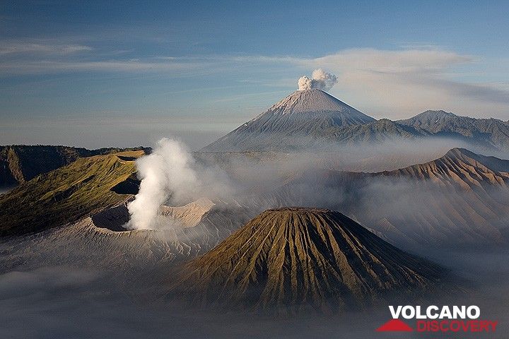 View across the Tengger caldera and an eruption at Semeru volcano. The smoking crater of Bromo volcano in the center image. (Photo: Tom Pfeiffer)