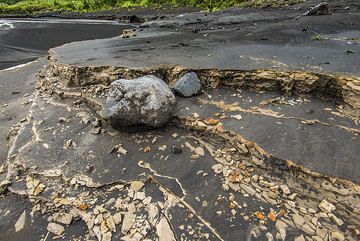 Eroded layers of older yellowish ash deposits covered by sandy ash from more recent activity. (Photo: Tom Pfeiffer)