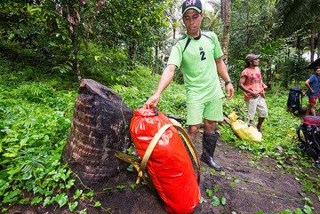 A porter adapting a dry bag into a backpack. (Photo: Tom Pfeiffer)