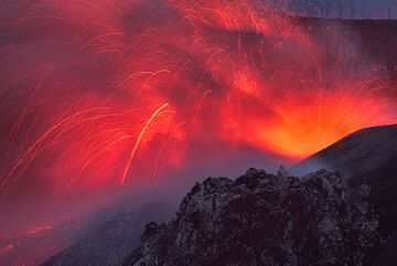 A stronger strombolian-type explosion occurs from the eastern vent at the end of dusk. (Photo: Tom Pfeiffer)