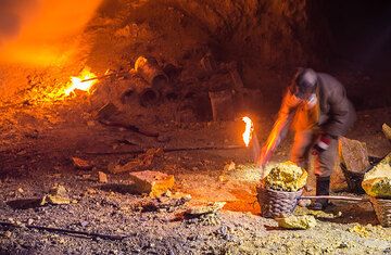 A miner is filling his basket with pieces of broken solidified sulfur. (Photo: Tom Pfeiffer)