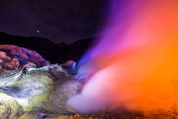 Depending on the way the sulfur plume moves, the intensity of the blue flames, presence of torches and headlamps, the red light mixes with blue, white as well green and yellow colors, making a sort of light-show. (Photo: Tom Pfeiffer)