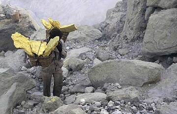 Mine worker carrying baskets of sulfur uphill (Photo: Tom Pfeiffer)