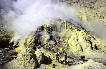 Fotos von Kawah Ijen, dem sauren türkisfarbenen Kratersee, Schwefelvorkommen, dem Bergbaubetrieb und Arbeitern vor Ort, die Körbe voller Rohschwefel tragen. (Photo: Tom Pfeiffer)