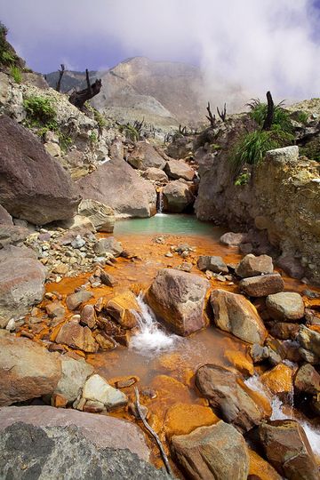 The acid creek inside the crater valley of the Papadayan volcano and red deposits of iron minerals. (Photo: Tobias Schorr)