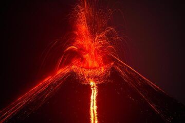 After the large bubble explosions, the effusion rate decreases and the lava flow starts slowly to weaken. At the summit strong strombolian activity continues. The vent of the lava flow can be seen from a depression just beneath the southern rim of the main crater (same spot where the 17 Oct explosion occurred). (Photo: Tom Pfeiffer)