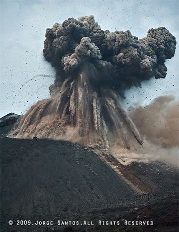 A fraction of a second later, the largest blocks are falling onto the slope of the cone, leaving dense trails of ash behind in the air, while the ash cloud expands, parts with a strong lateral component. (Photo: Jorge Santos)