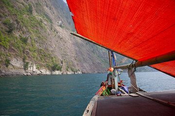 Sailing around the steep cliffs of Rakata island on a traditional fishing boat. (Photo: Tom Pfeiffer)