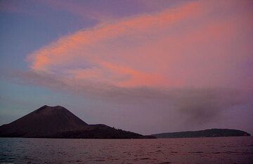 Le panache diffus de cendres grises de la troisième éruption dérive bien en dessous du panache désormais très diffus de la première et de la deuxième explosion, coloré en rouge par le soleil couchant. (Photo: Tom Pfeiffer)