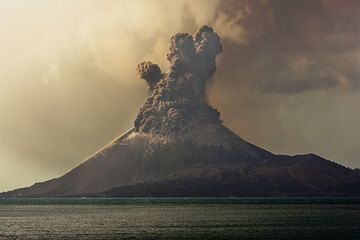 A vulcanian explosion producing a dense cloud of ash and rock fragments ejected from the crater. Blocks impacting on the upper slope leave dust trails. (Photo: Tom Pfeiffer)