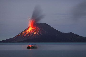 21 Nov: a small but bright eruption leaves a reflection on the calm sea.  (Photo: Tom Pfeiffer)
