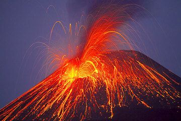 Powerful strombolian eruption; some blocks become first visible when they leave the black ash cloud. (Anak Krakatau) (Photo: Tom Pfeiffer)