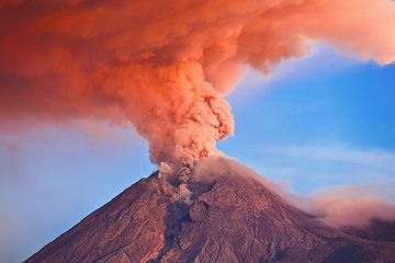 Mt Merapi (Central Java, Indonesia) in eruption with the ash column illuminated at sunrise (Nov 2010) (Photo: Tom Pfeiffer)