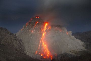 Glowing rockfall from the moonlit lava dome (1 Dec). (Photo: Tom Pfeiffer)