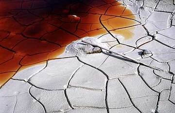 Un estanque de secado fuera que contenga agua roja mirando mal dentro del cráter del volcán Papandayan. (Photo: Tom Pfeiffer)