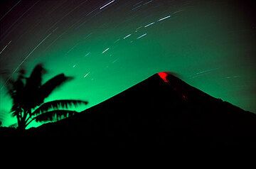 Ausbruch des Semeru-Vulkans in der Nacht (März 2004) – eine kleine Explosion stößt glühende Bomben aus, die über seine Südflanke rollen. (Photo: Tom Pfeiffer)