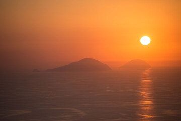 Tramonto dietro (l) di Filicudi e Alicudi (r) isole. (Photo: Tom Pfeiffer)