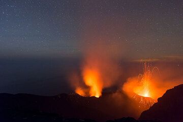 Glow and steaming from the NW vent and an eruption of the NE vent of Stromboli at night (Photo: Tom Pfeiffer)