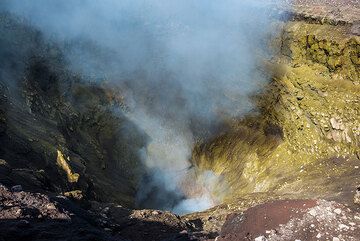 La mayoría de las paredes internas del cráter NE están cubiertas por depósitos de azufre amarillo, resultado de la constante desgasificación. (Photo: Tom Pfeiffer)