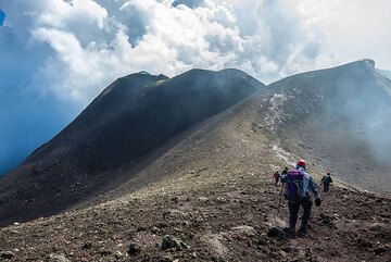 Descending from NE crater; the New NE crater in the left background. Today, only sporadic ash emissions were seen from it. (Photo: Tom Pfeiffer)