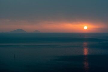 Coucher de soleil sur la mer Tyrrhénienne, silhouettes des îles Filicudi et Alicudi à l'horizon gauche. (Photo: Tom Pfeiffer)