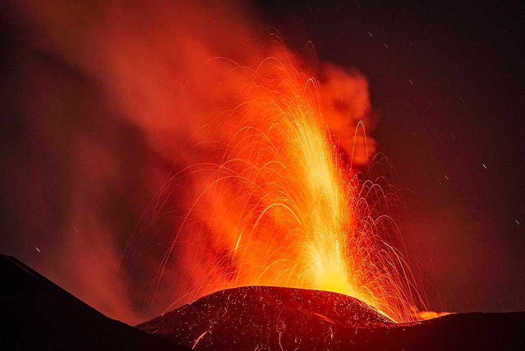 In June 2024, Etna's central summit crater known as Voragine became active again after 3 years of  quiescence. Mild strombolian activity from a new vent gradually built an intra-crater cone. It gradually increased to a first violent lava fountaining episode (paroxysm) on 4 July, followed by a second one on 7 July, and a 3rd one on 15 July. 
The 4th paroxysm eventually occurred a week later on 23 July and was witnessed by Tom who visited friends on Etna during the week between the 3rd and the 4th paroxysm.  (Photo: Tom Pfeiffer)