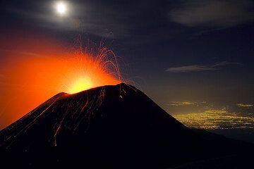 Strombolian activity at Etna's SE crater in October 2006. The lights of Catania in the background. (Photo: Tom Pfeiffer)