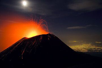 Actividad estromboliana en el cráter SE del Etna en octubre de 2006. Las luces de Catania al fondo. (Photo: Tom Pfeiffer)