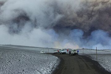 Bluish gas from SO2 drifting beneath the dark ash plume mixes with white steam and the clouds. (Photo: Tom Pfeiffer)