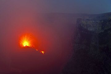 Nahezu kontinuierliches starkes Spritzen und Ergießen eines kleinen Lavastroms aus dem neuen Intra-Krater-Kegel erhellt den Bocca Nuova-Krater des Ätna (3. August 2012). (Photo: Tom Pfeiffer)