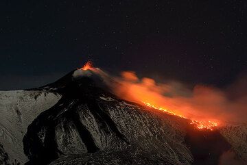 Mild strombolian eruptions from the summit vent of the New SE crater (NSEC) and the lava flow from the effusive vents at its base on the evening of 8 Feb 2014. (Photo: Tom Pfeiffer)
