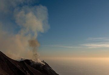 A small, "dry" explosion with mostly only lava bombs and little ash occurs from the prominent N2 crater - in daylight, the lava fragments are not very bright. (Photo: Tom Pfeiffer)