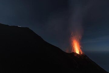 Eine Weitwinkelaufnahme mit Pizzo auf der linken Seite, wo eine Gruppe Kletterer mit ihren Stirnlampen Spuren hinterlässt. (Photo: Tom Pfeiffer)